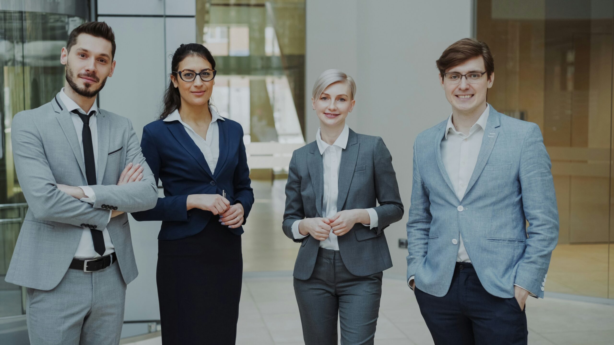 A team of professionals collaborating around a tablet, representing a transparent discussion about total rewards and employee engagement data.