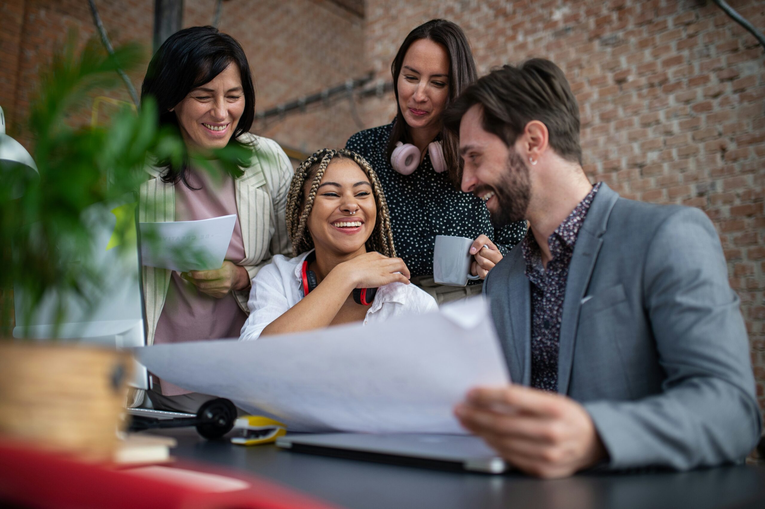 highly engaged team in a modern office collaborating on a project, demonstrating the positive workplace culture essential for employee retention.